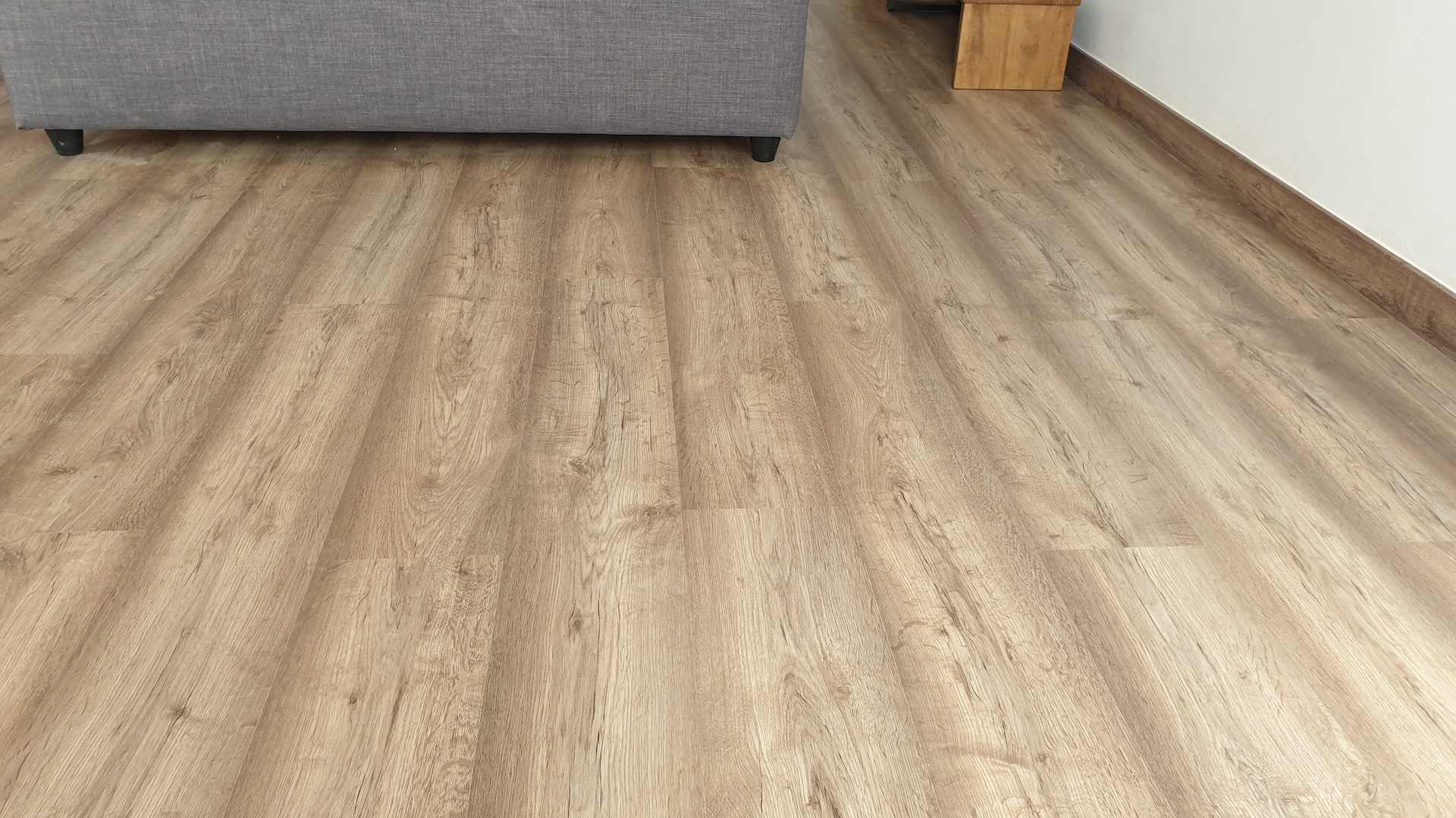 La empresa Pintparket coloca un parquet laminado ac 4 de estilo rústico con rodapié a Mataró