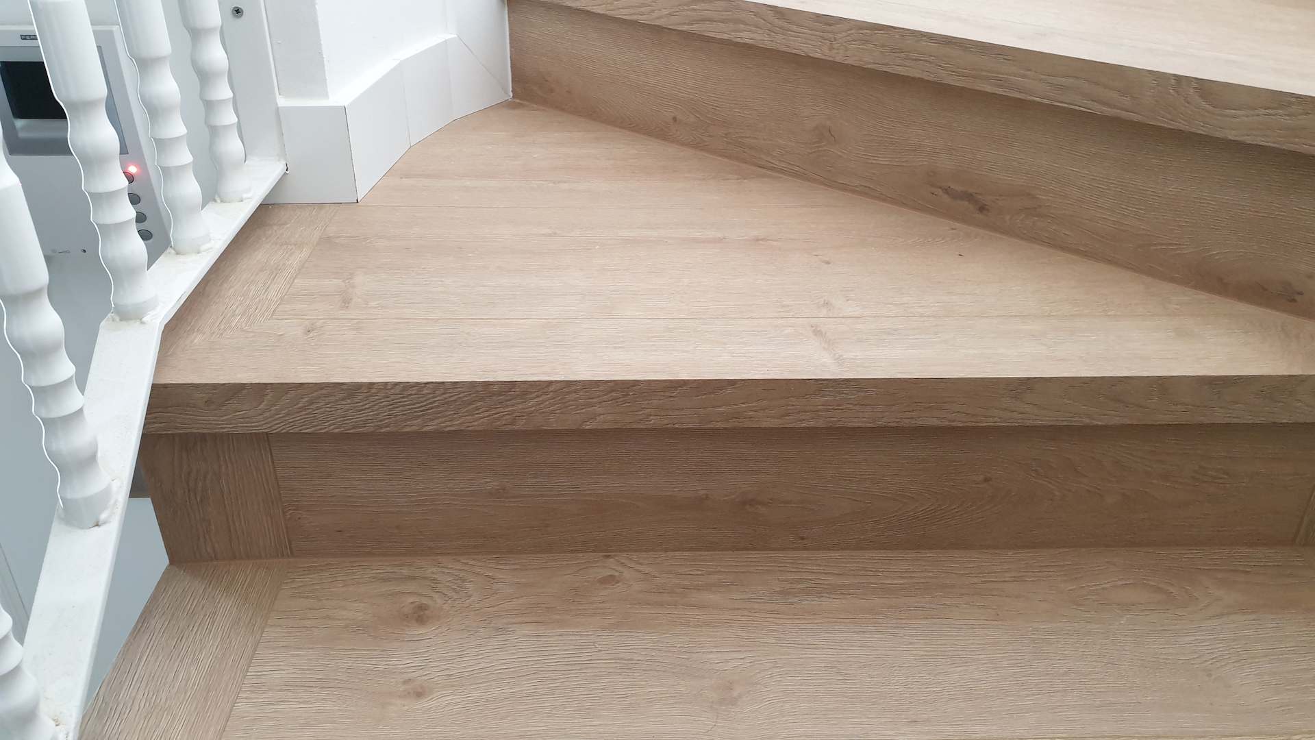 Instalacion de suelo de madera sintético con color mate en unas escaleras curvadas
