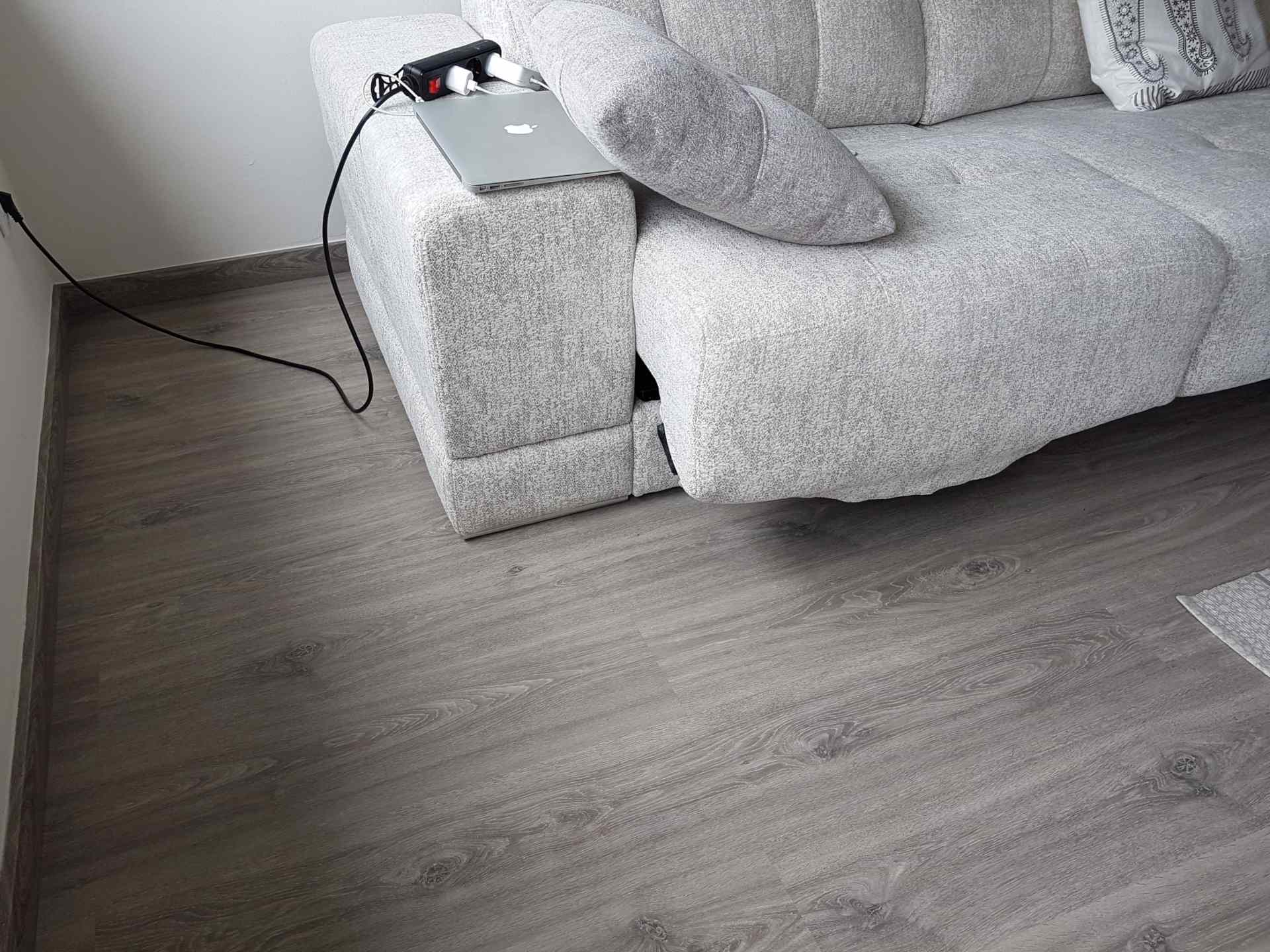 Instalación de un suelo laminado gris oscuro en un comedor moderno de un piso de Hospitalet