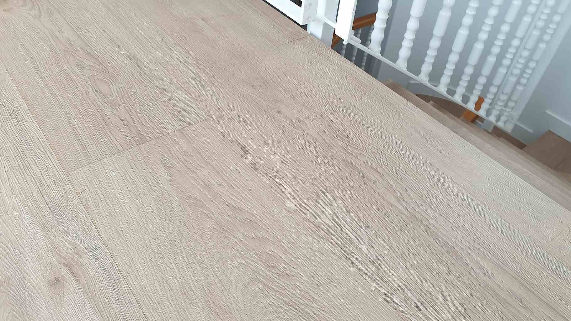 Suelo de parquet laminado de color claro natural instalado en un piso con escaleras en Sabadell