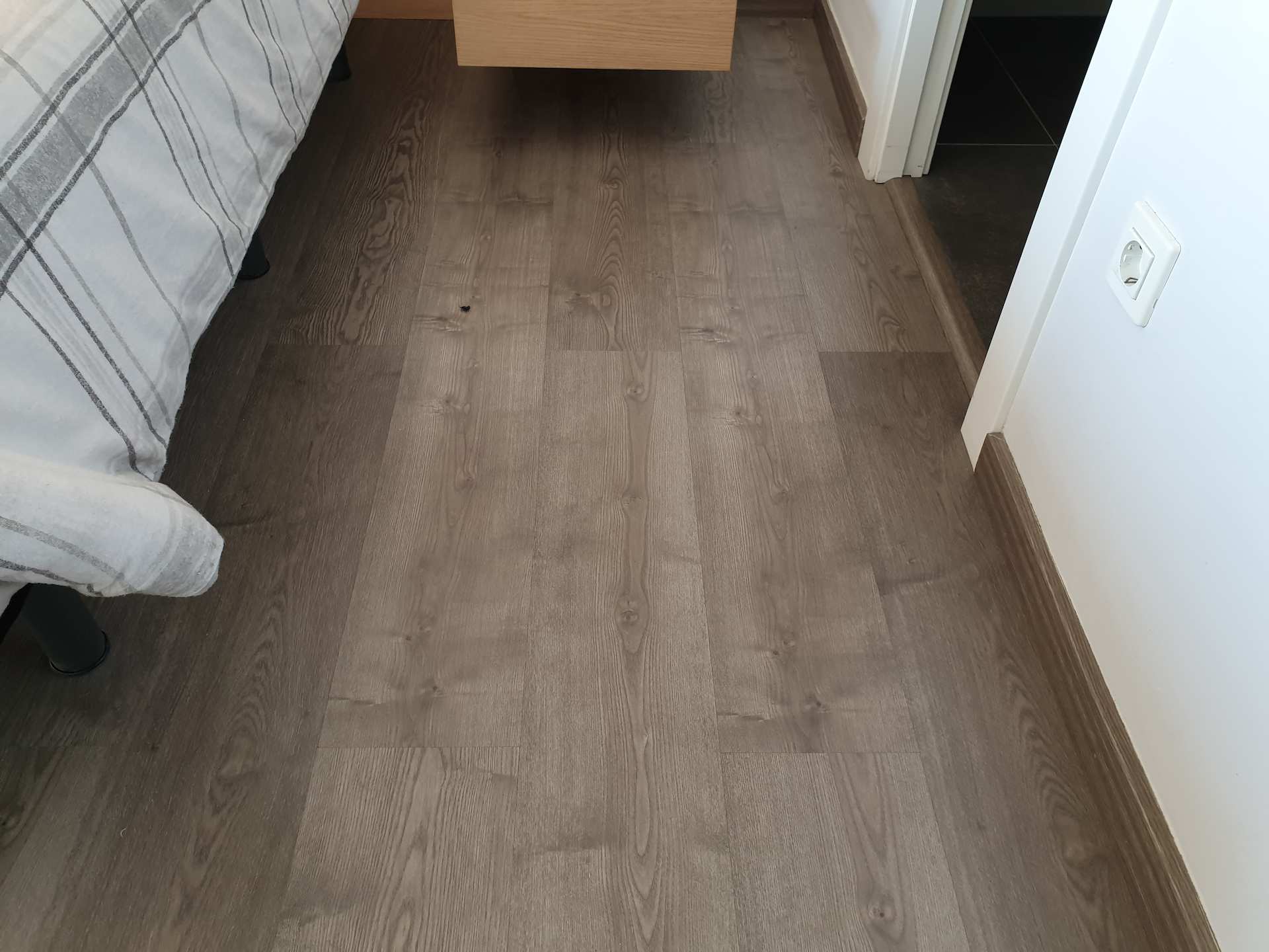 Muestra de como Pintparket pone un parquet laminado ac4 de color marron oscuro para una sala