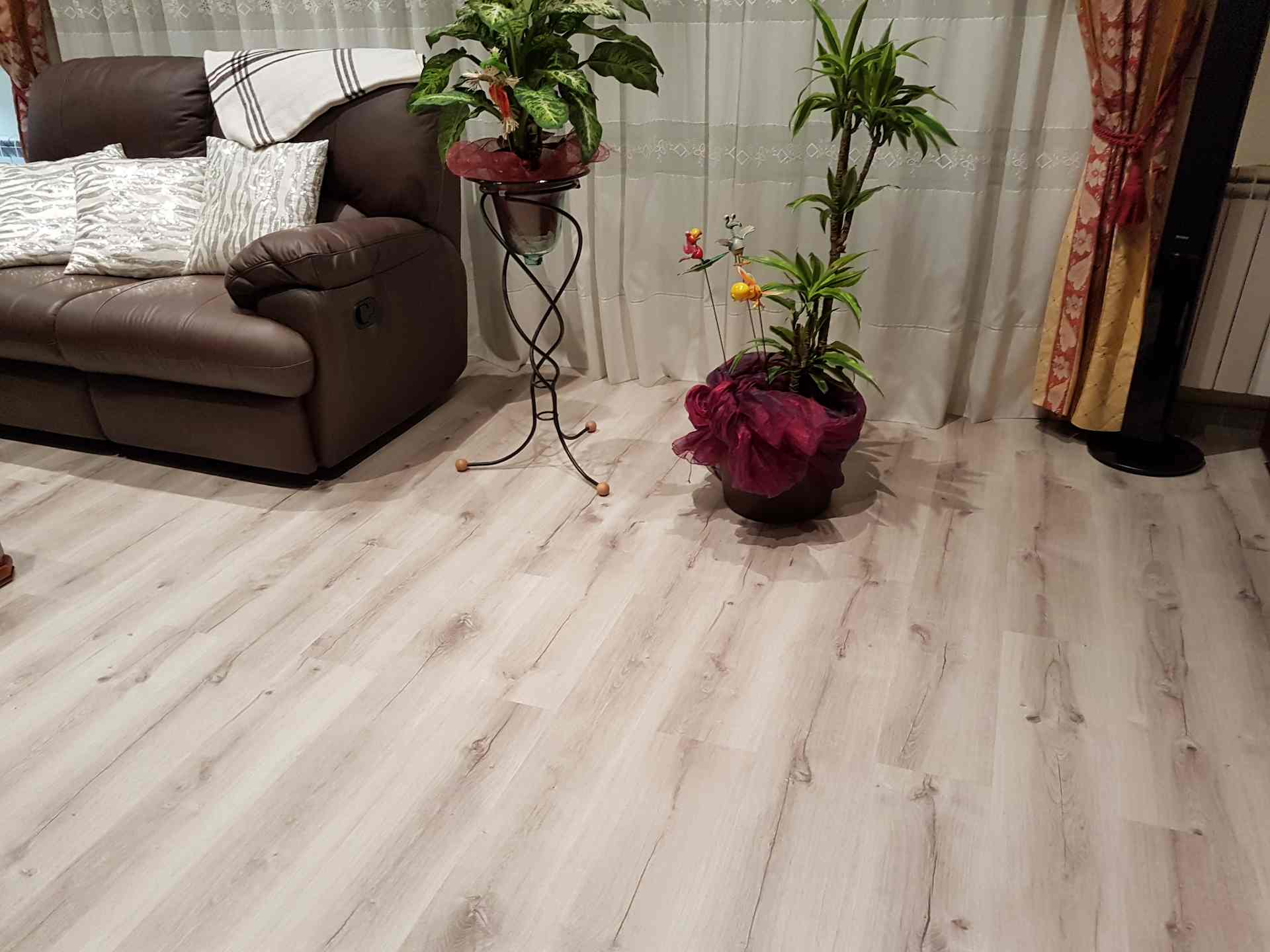 Instalación en una sala de estar de Terrassa de parquet de color blanco roto con betas oscuras