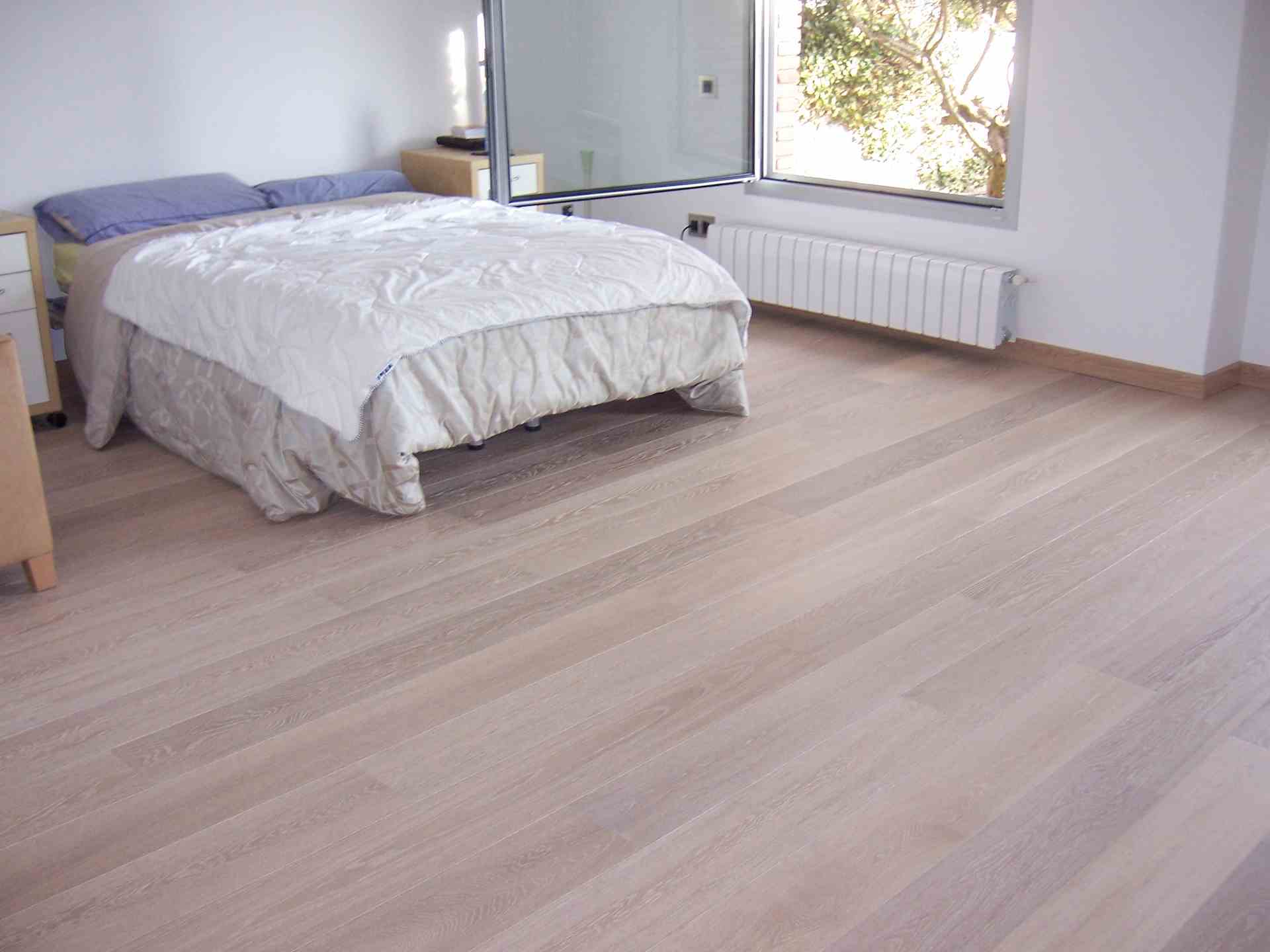 Instalación de tarima flotante finsa roble retro en un dormitorio con cama de matrimonio en Sabadell
