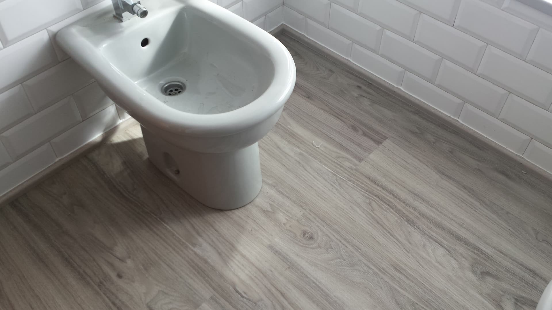 Suelo laminado de color gris resistente al agua y a la humedad para baños