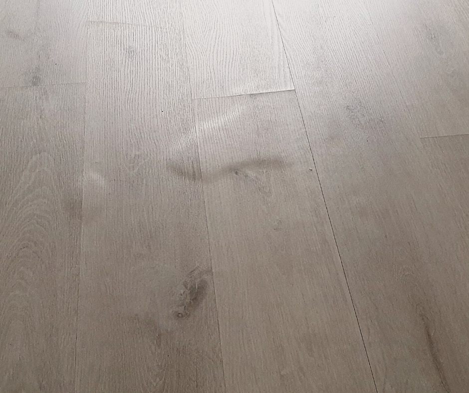 Superfície de parquet ac3 barato de color gris levantada e hinchada por no ser resistente al agua