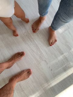 Familia pisando con los pies el parquet laminado Quick-Step roble irlandés de color blanco rústico