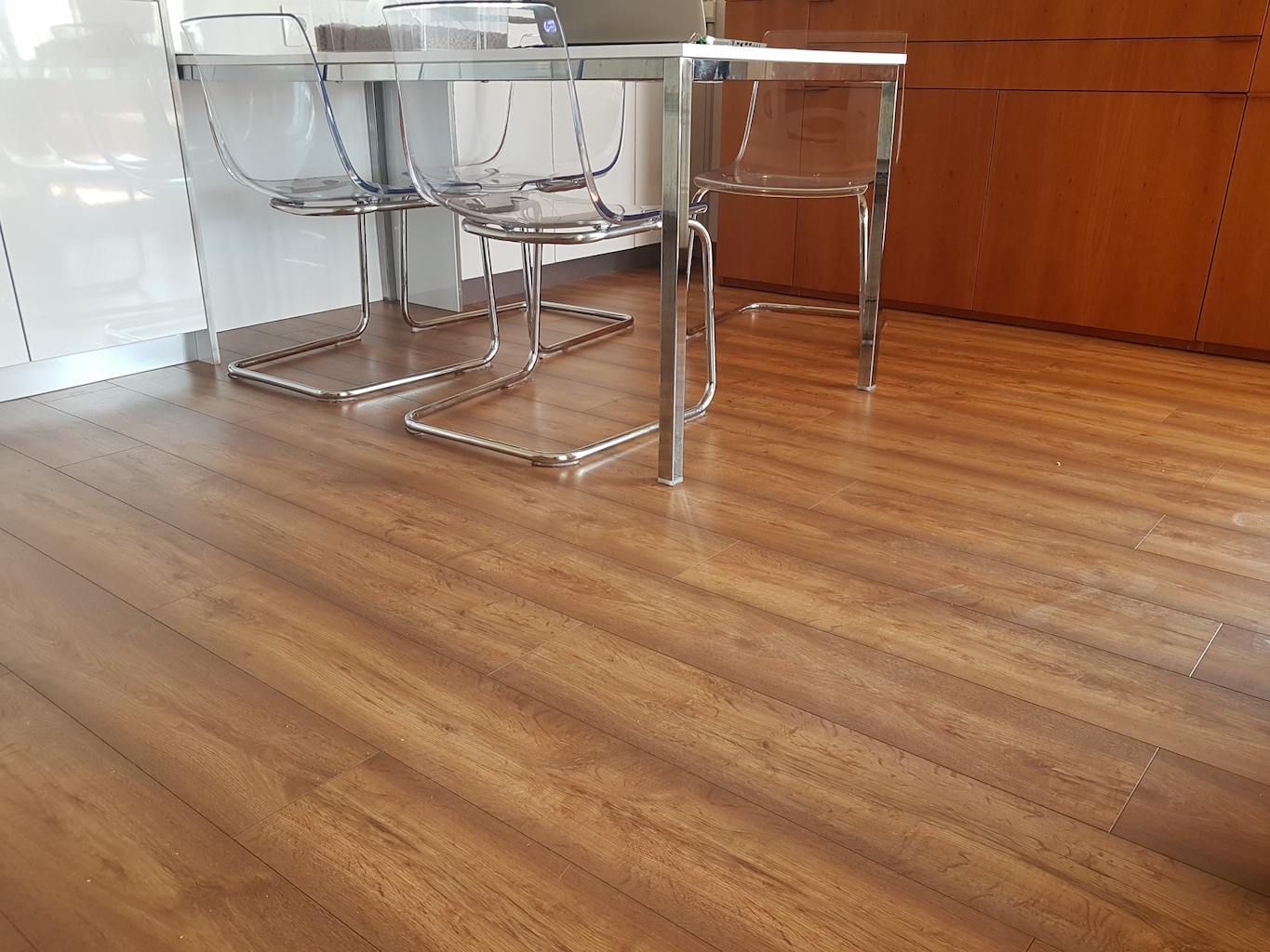 Instal·lació de terra laminat AC5 de roure fosc i textura mat en escales de cargol amb mamperlà