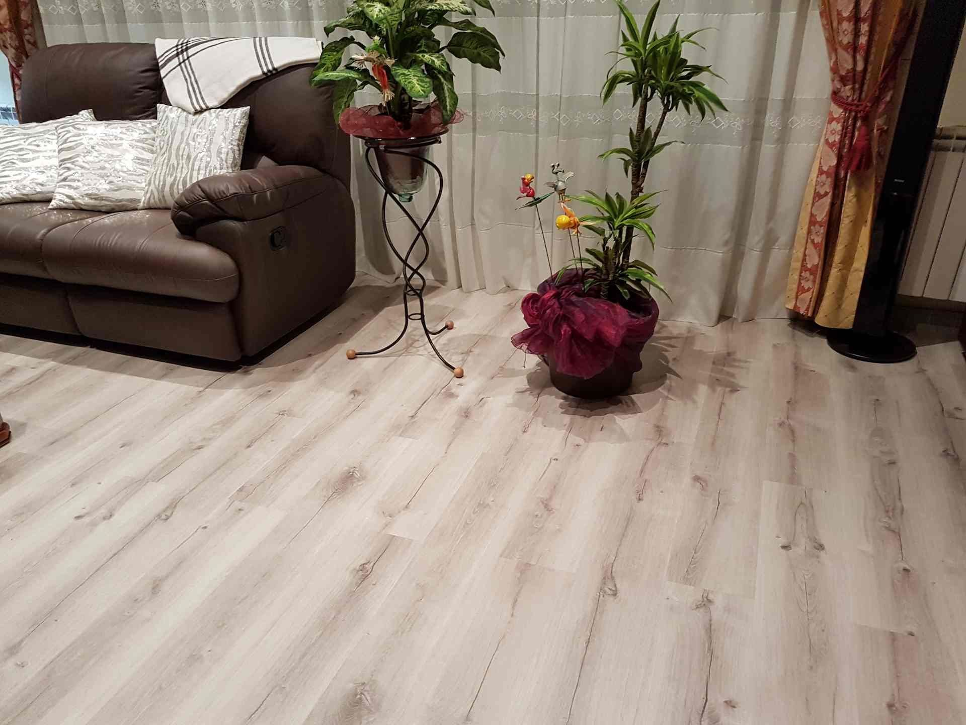 Instal·lació en una sala d'estar de Terrassa de parquet flotant de color blanc trencat amb betes fosques