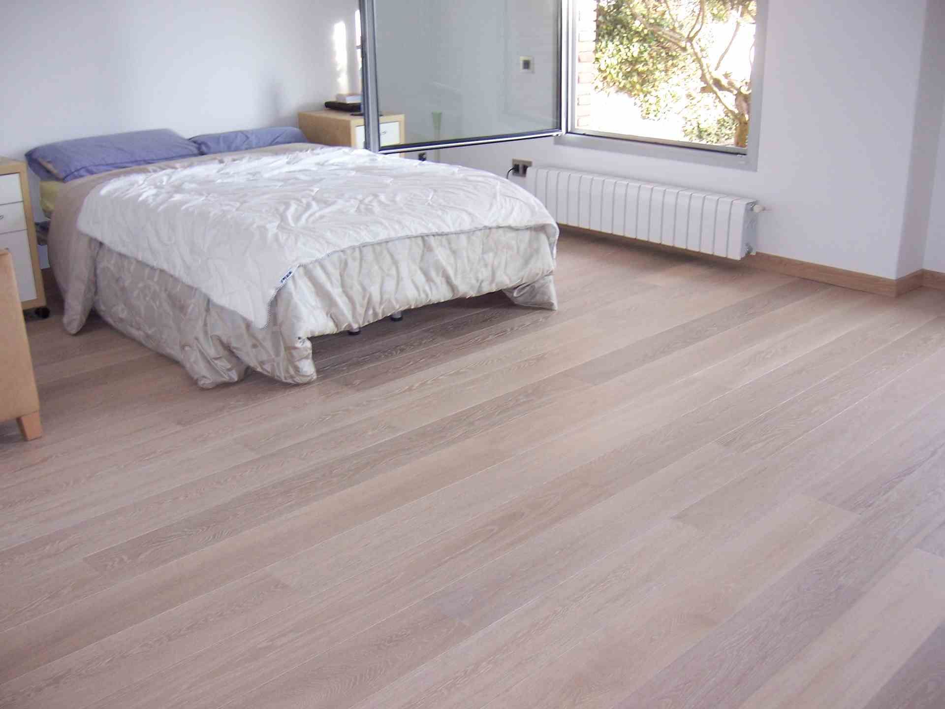 Instal·lació de tarima flotant finsa roble retro en un dormitori amb llit de matrimoni a Sabadell