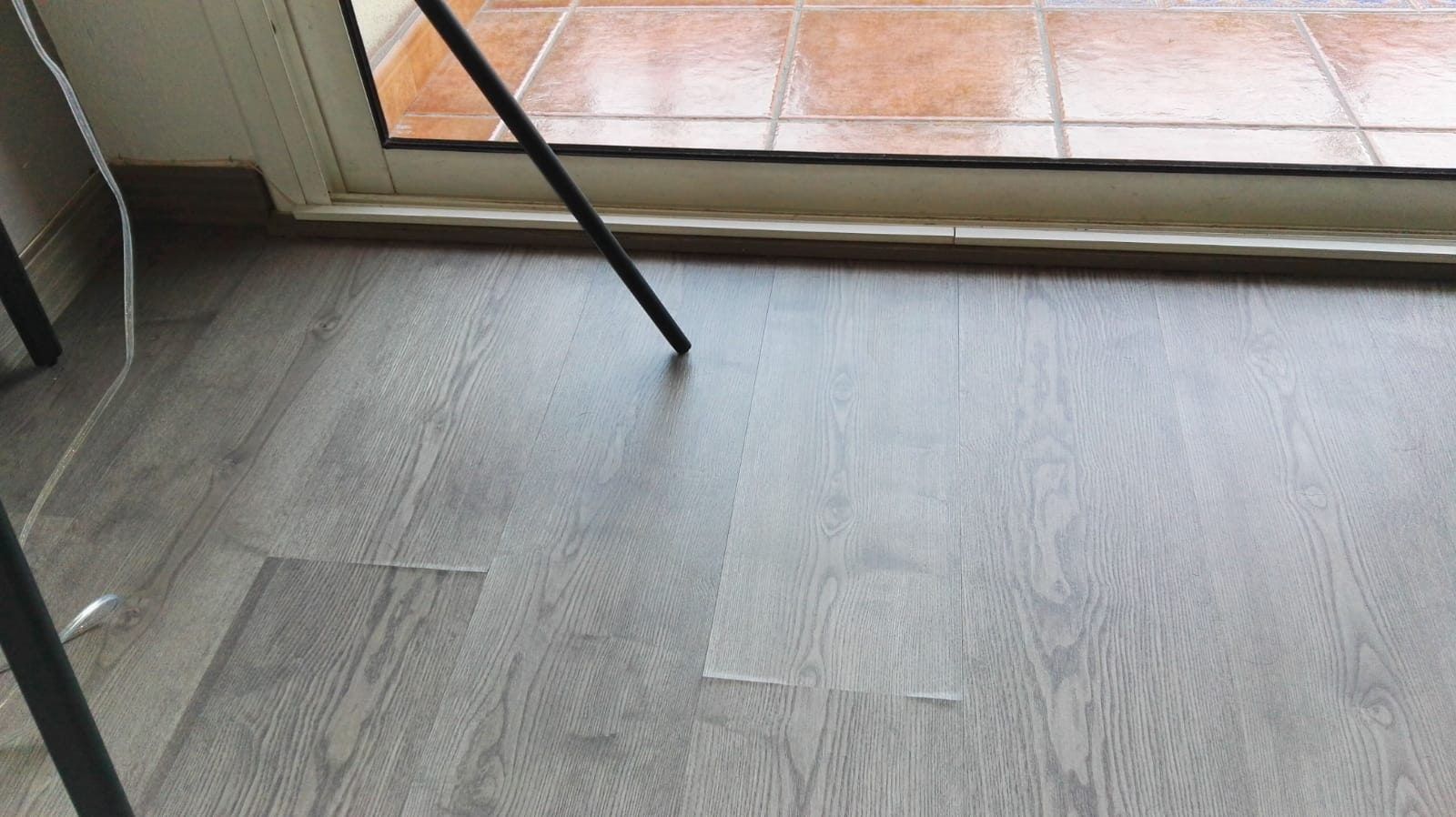 parquet laminado de color gris hinchado por la humedad del ambiente